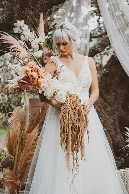 Bride holding flowers while posing
