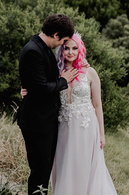 Groom holding his bride Molteno Couture designer bridal cape town pink hair bride gothic wedding