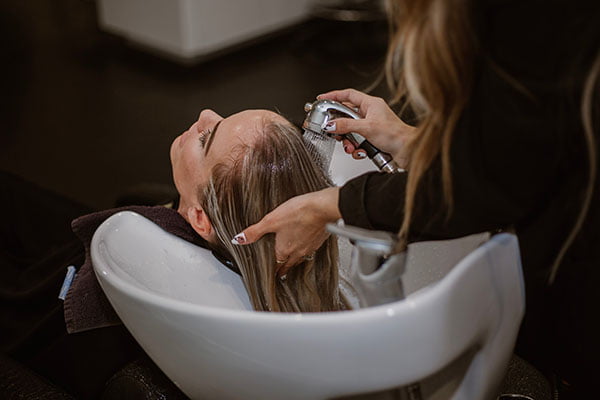 Woman getting hair washed at salon